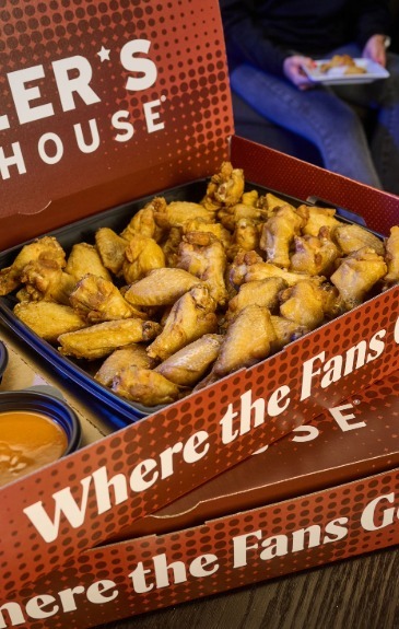 a large red miller's ale house branded box with chicken wings and sauces inside