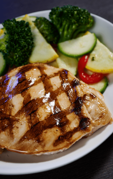 grilled chicken breast for kids with a side of veggies placed on a plate